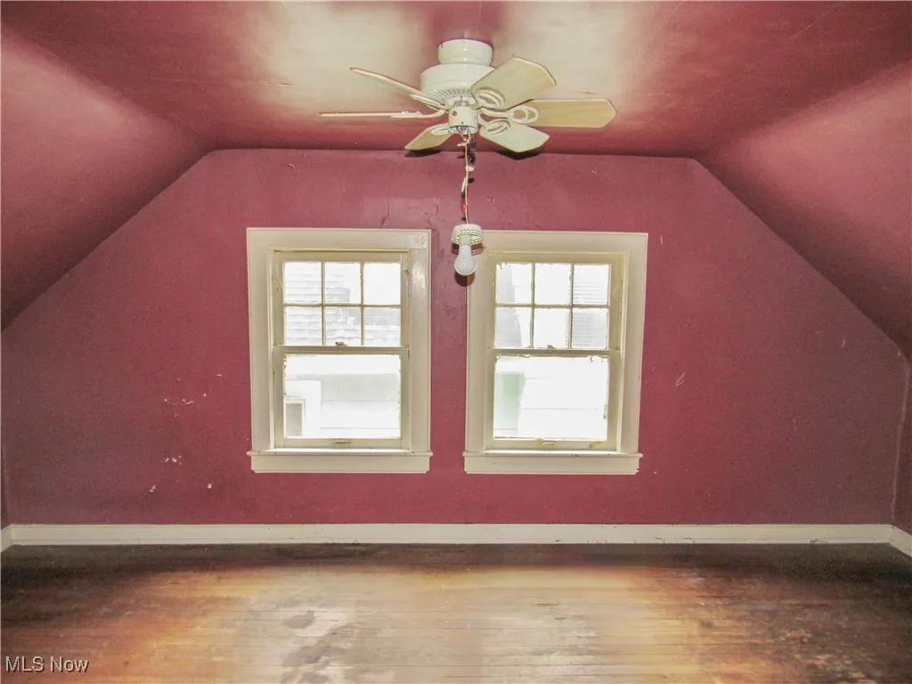 Additional living space with lofted ceiling, hardwood / wood-style floors, and plenty of natural light