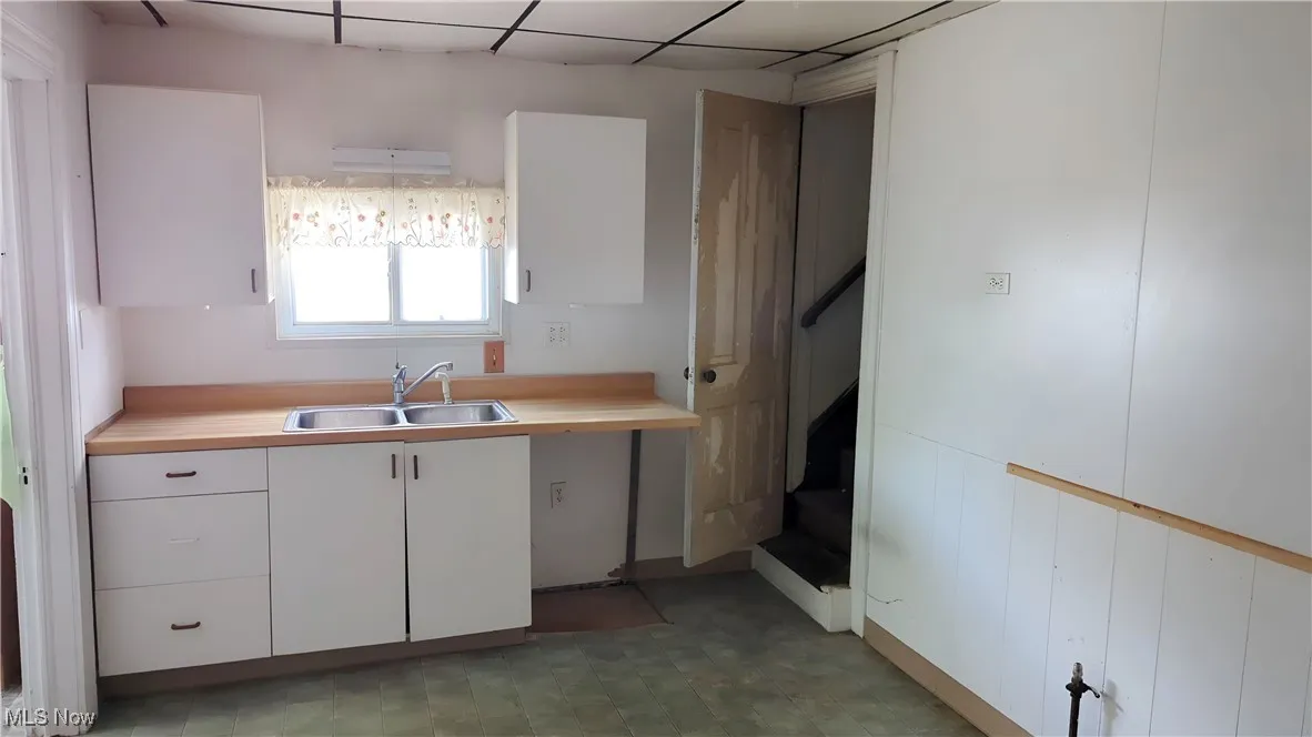 Kitchen featuring a sink and white cabinets