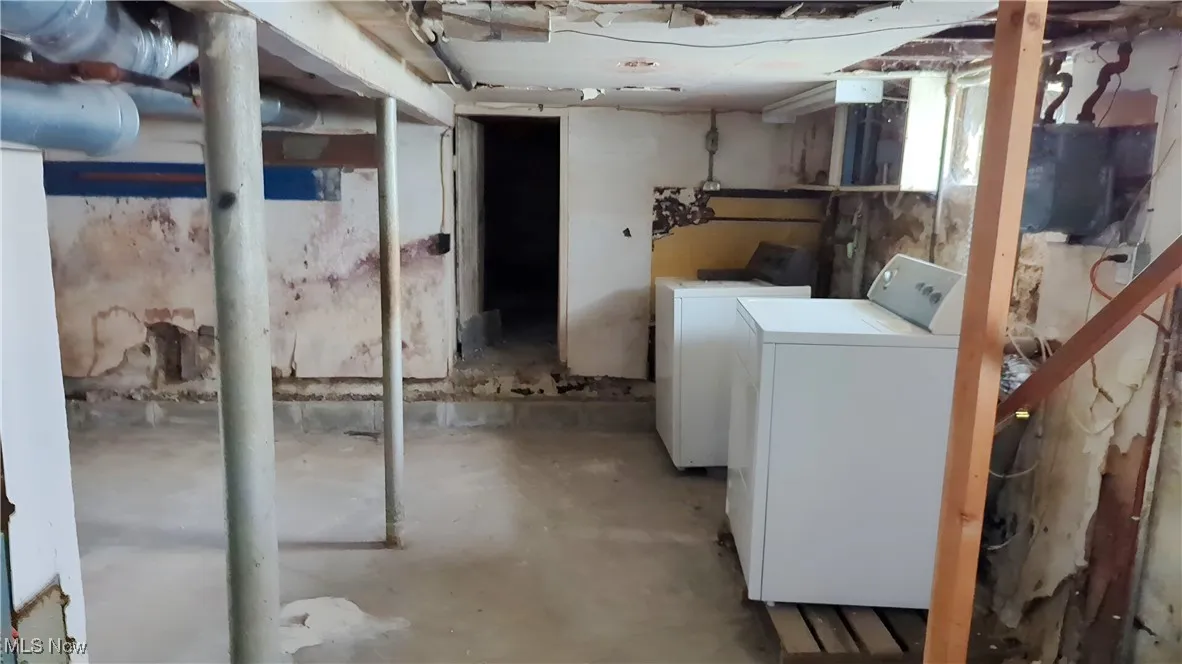Unfinished basement featuring washing machine and dryer