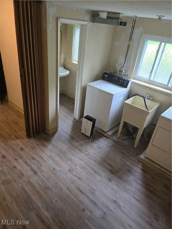 Laundry area featuring wood finished floors