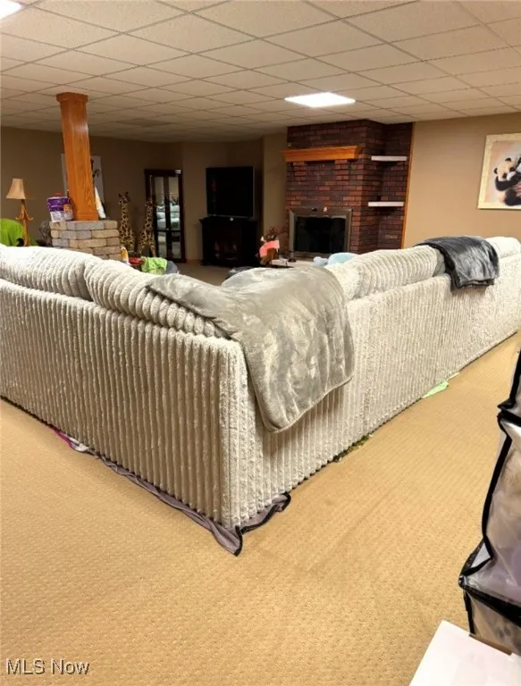 Carpeted living room with a brick fireplace