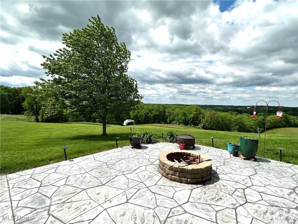View of patio with an outdoor fire pit