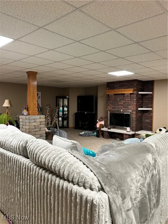 Carpeted living area with a brick fireplace and a drop ceiling