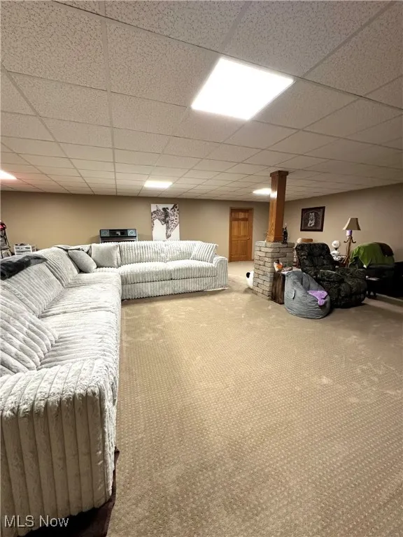 Carpeted living room featuring a drop ceiling