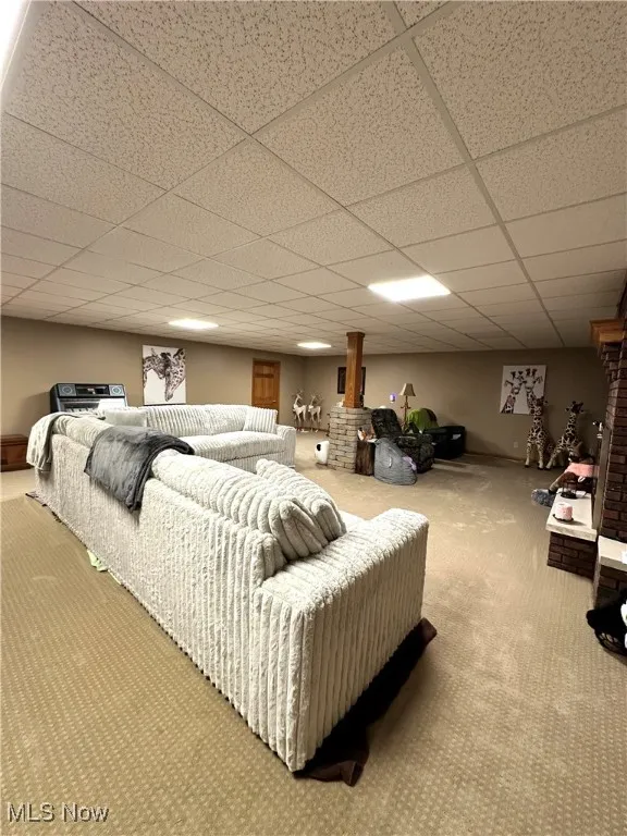 Carpeted living room with a paneled ceiling