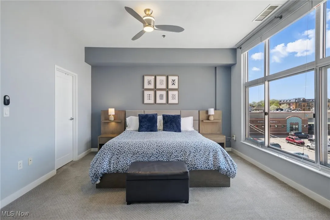Bedroom featuring carpet floors, visible vents, a ceiling fan, and baseboards