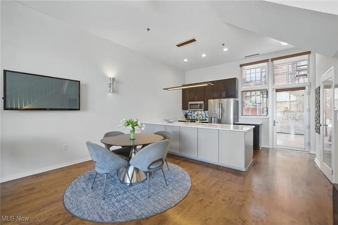Dining space with baseboards, wood finished floors, visible vents, and recessed lighting