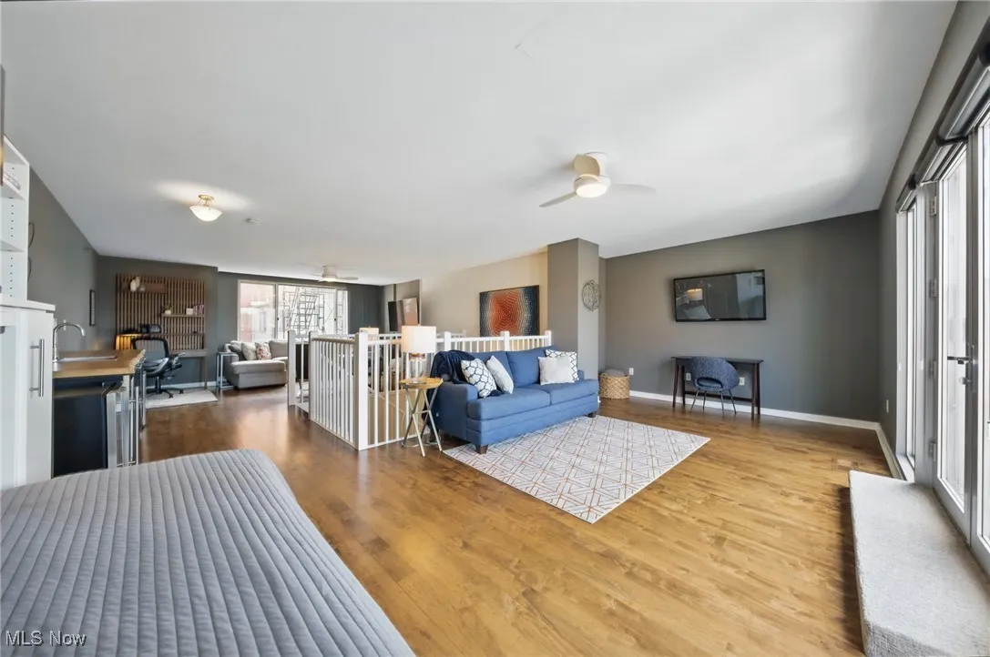 Living room with ceiling fan, baseboards, and wood finished floors