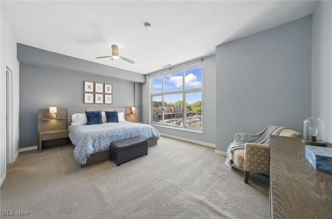 Carpeted bedroom with baseboards and a ceiling fan