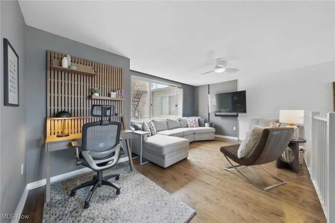Living room with wood finished floors, baseboards, and a ceiling fan