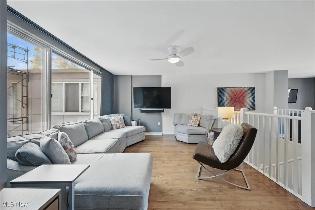 Living area featuring baseboards, a ceiling fan, and wood finished floors
