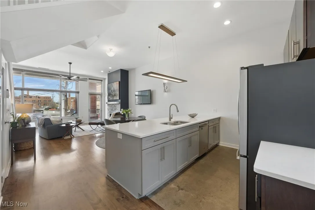 Kitchen featuring stainless steel appliances, a ceiling fan, a sink, a peninsula, and open floor plan