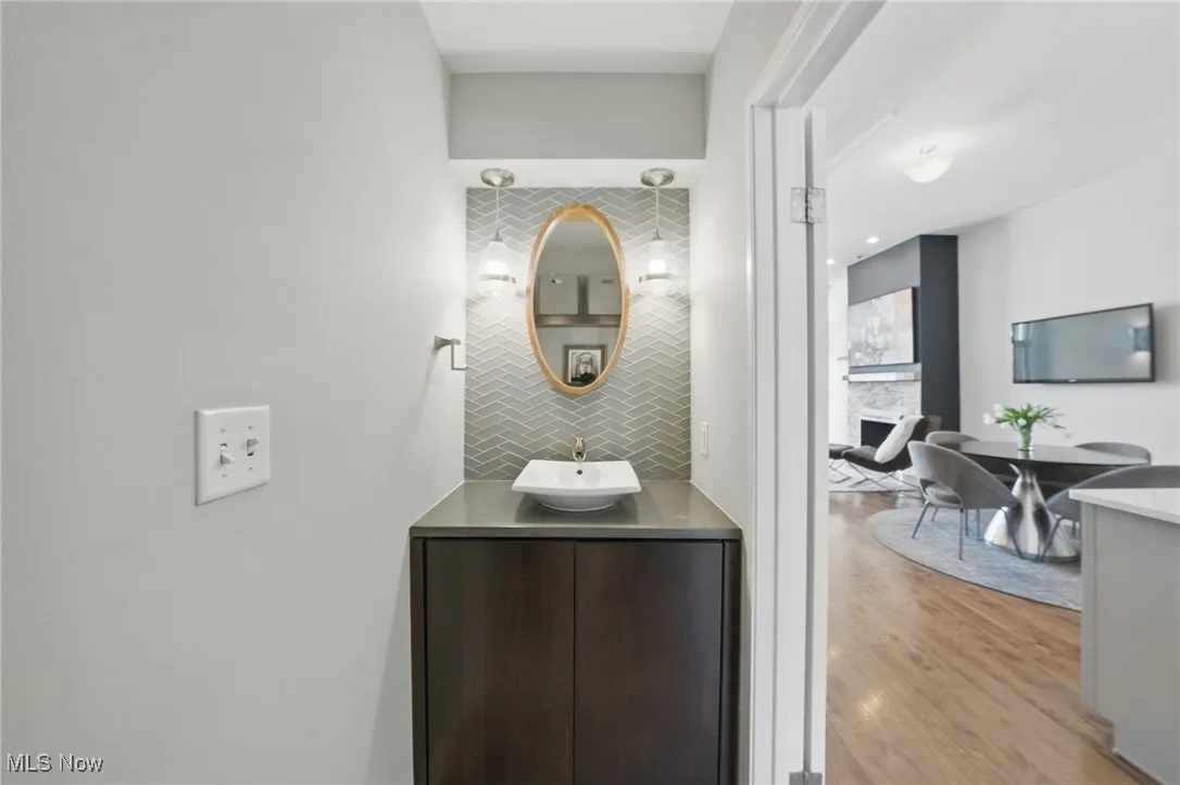 Bathroom featuring backsplash, wood finished floors, and vanity