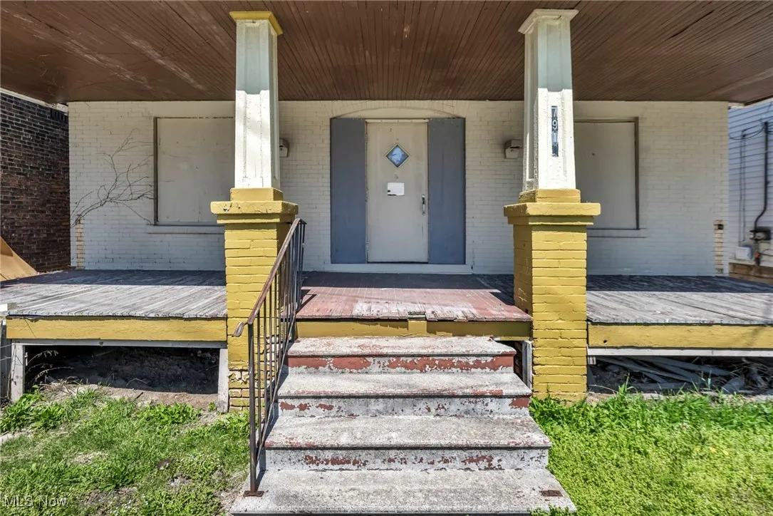 Property entrance with covered porch and brick siding