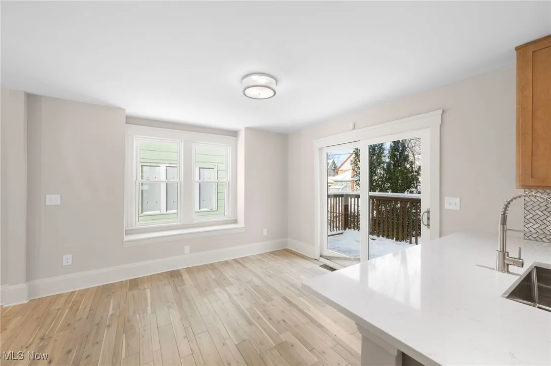 Unfurnished dining area with light wood style finished floors, baseboards, and sliding door to back yard