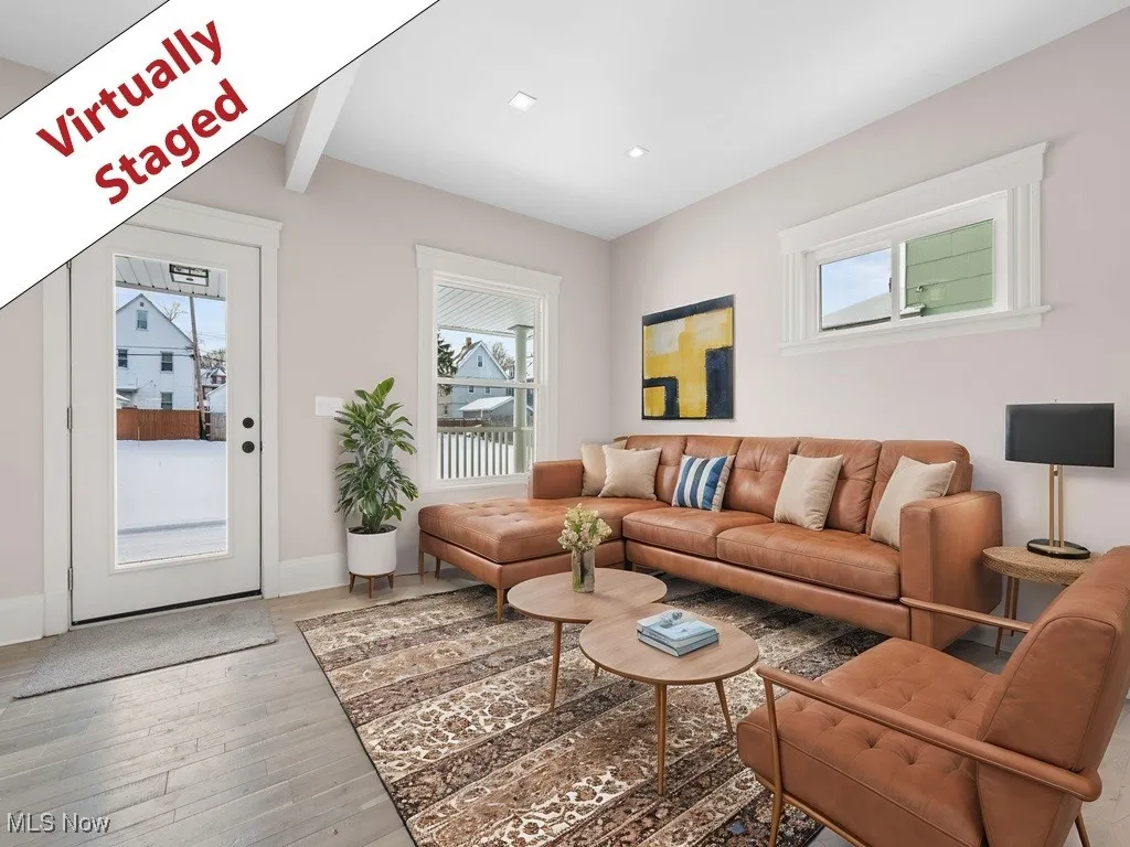 Living room with baseboards, beamed ceiling, light wood-type flooring, and plenty of natural light