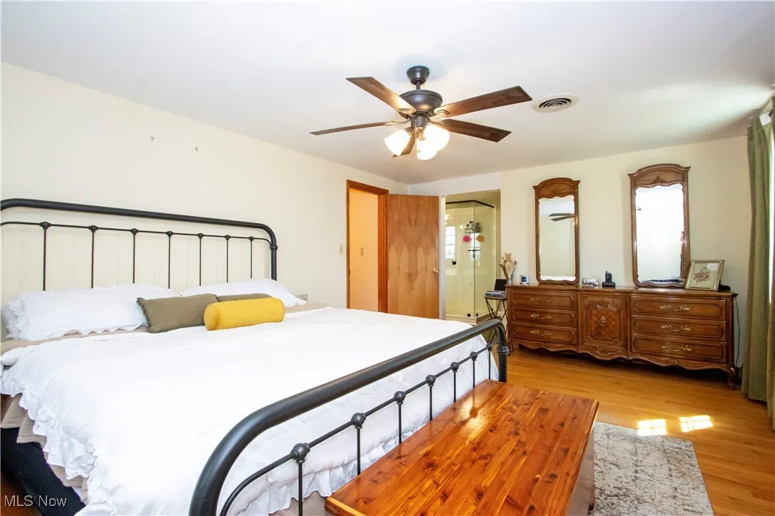 Bedroom with ceiling fan, visible vents, and light wood-type flooring