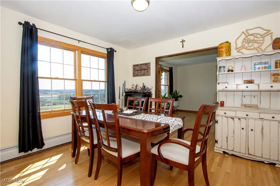 Dining space featuring baseboard heating and light wood-style flooring