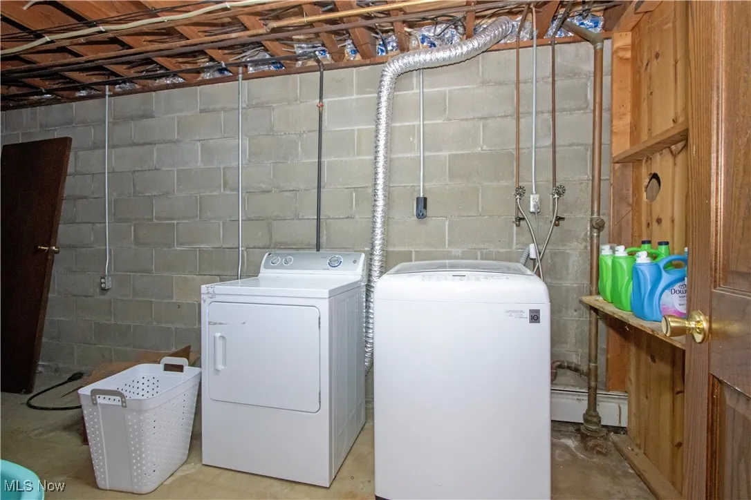 Laundry area with washing machine and dryer, laundry area, and a baseboard radiator