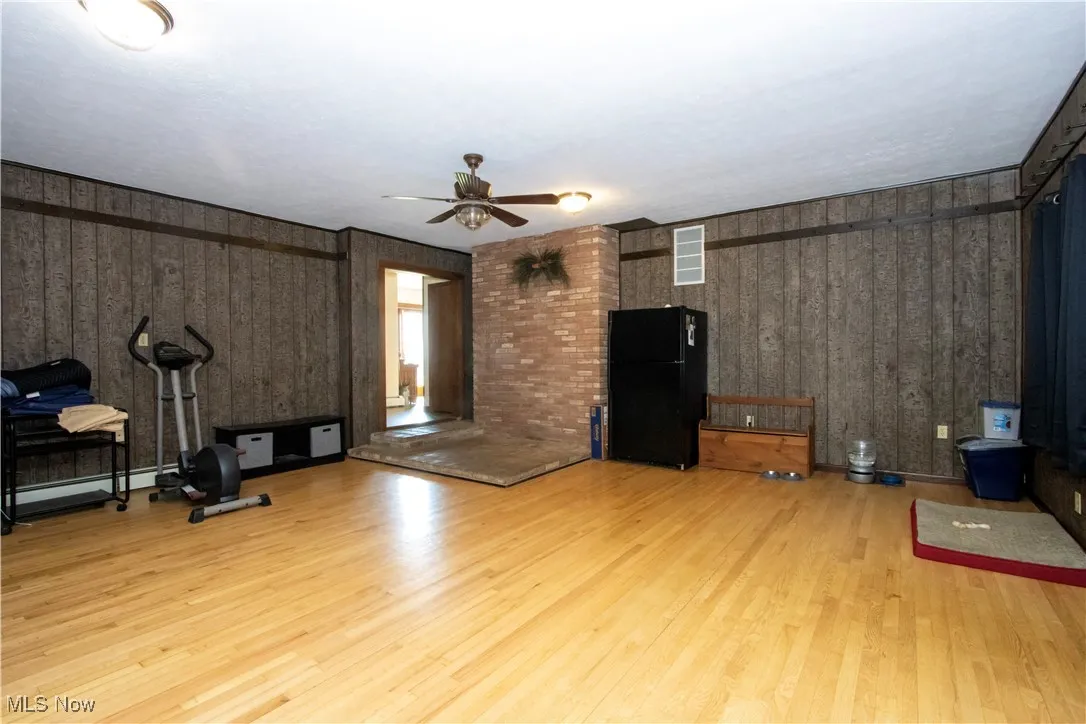 Living area with visible vents, light wood-type flooring, and ceiling fan