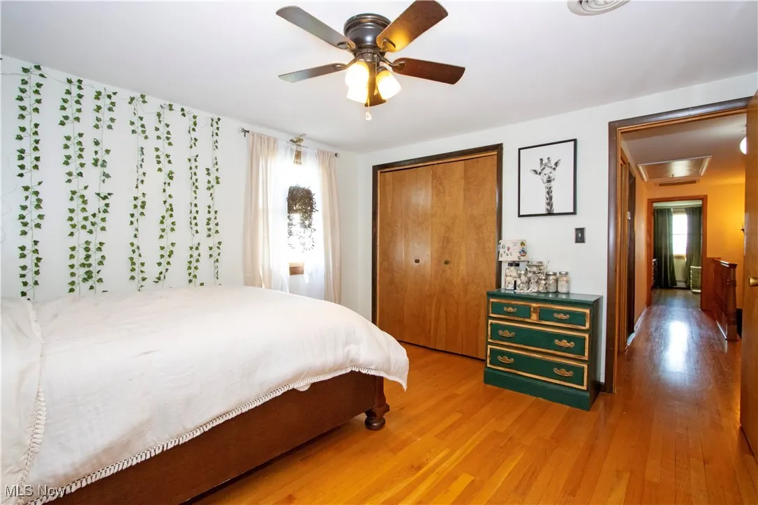 Bedroom with a closet, a ceiling fan, and wood finished floors