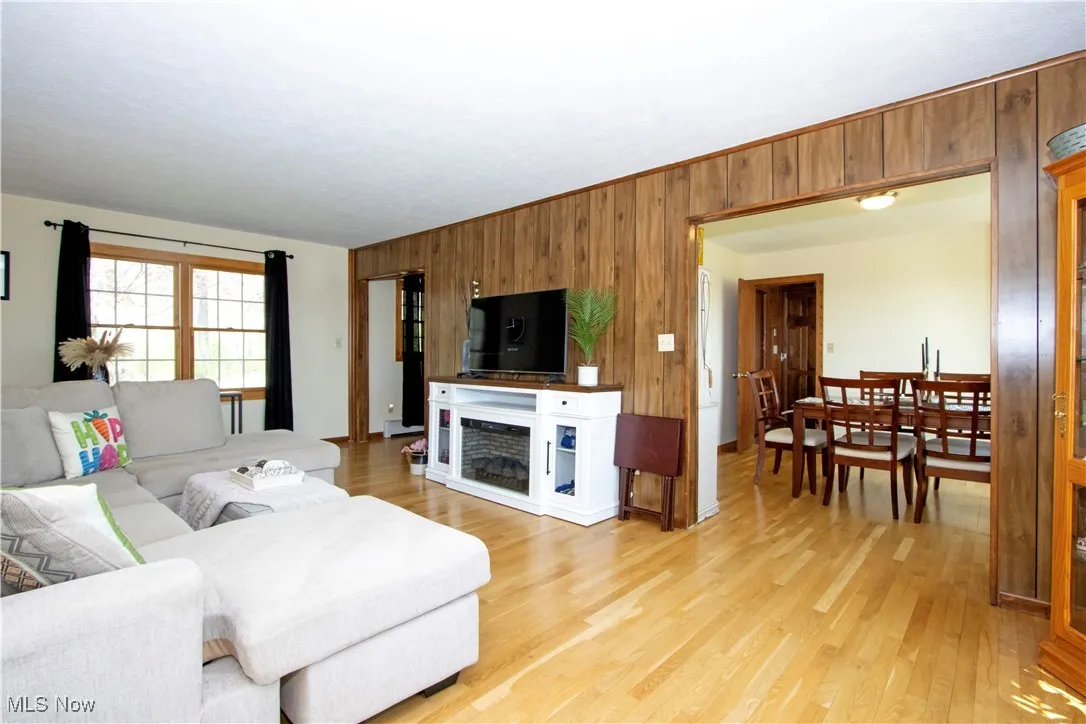 Living area featuring light wood-style flooring, wood walls, and a fireplace