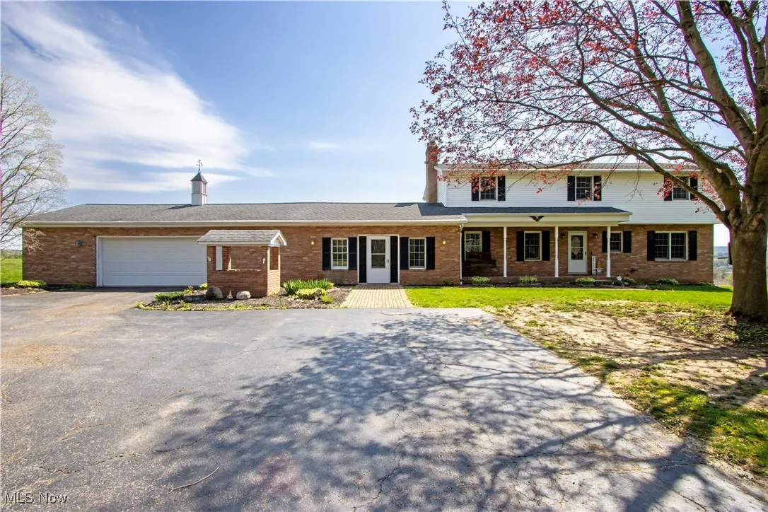 Traditional home with brick siding, a garage, and aphalt driveway