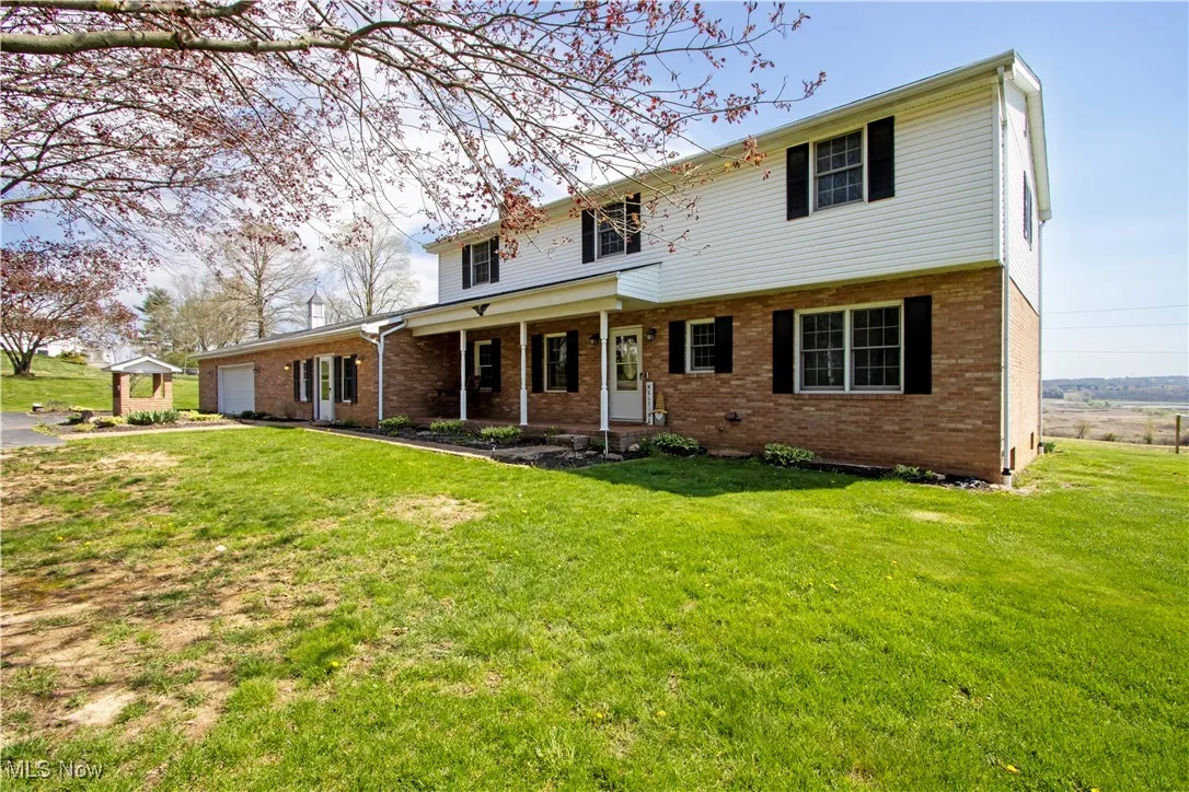 Traditional-style house with a front yard, brick siding, and a garage