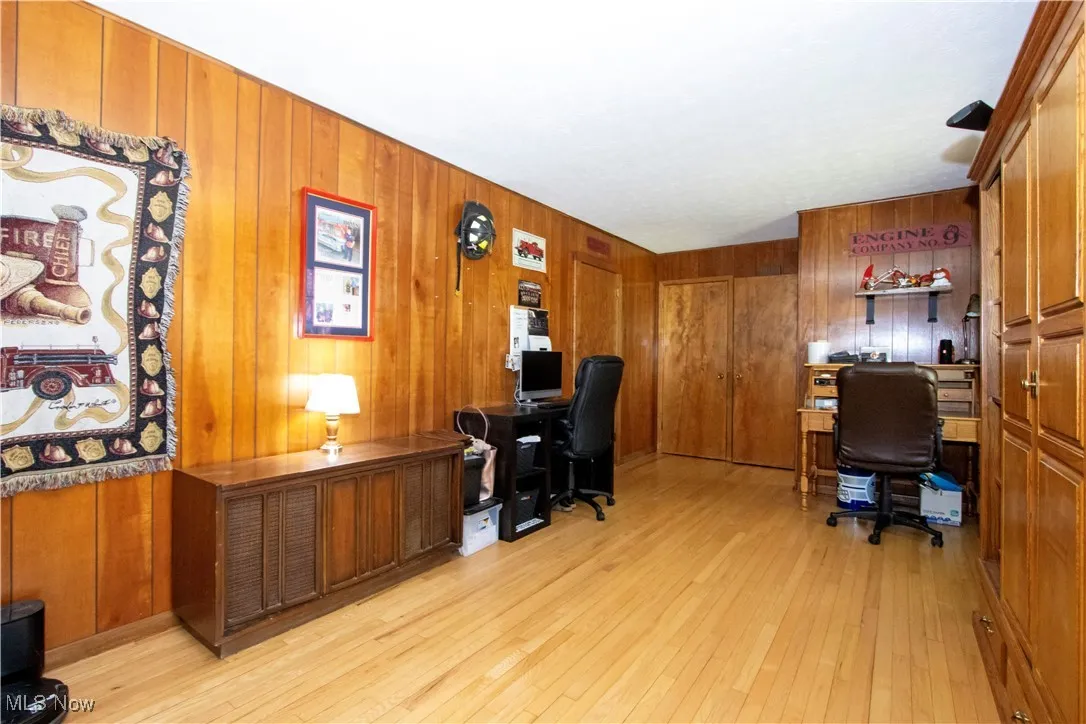 Office with wood walls and light wood finished floors