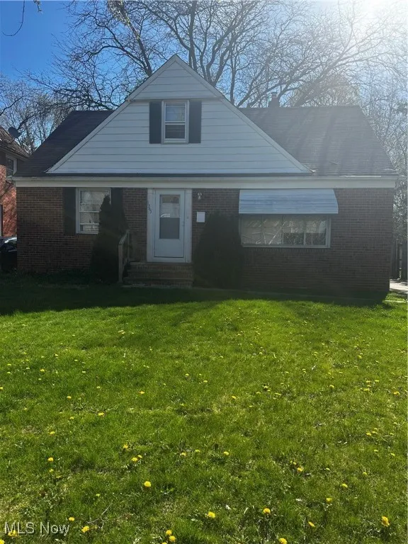 Bungalow-style house featuring a front yard, entry steps, and brick siding