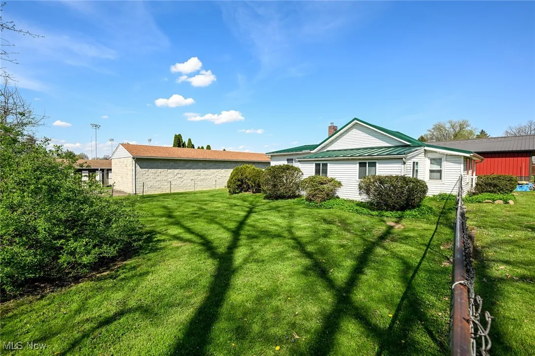 View of front of property with a chimney, metal roof, a front lawn, and a standing seam roof