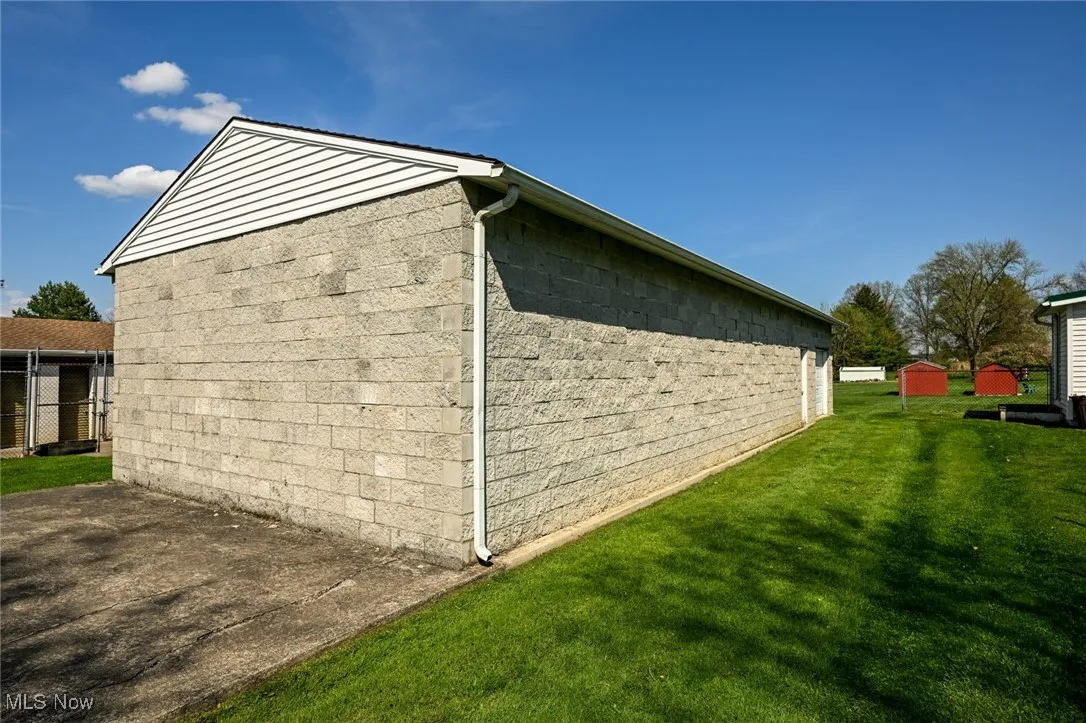View of property exterior featuring an outbuilding, a storage shed, and a yard