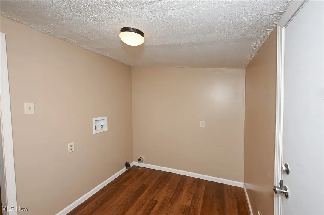 Laundry room with hookup for a washing machine, dark wood-style flooring, laundry area, and baseboards