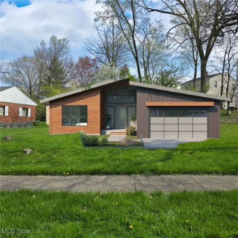 front view. Contemporary home with a garage and a front lawn