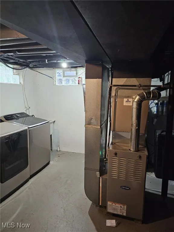 Below grade area with heating unit and washing machine and dryer