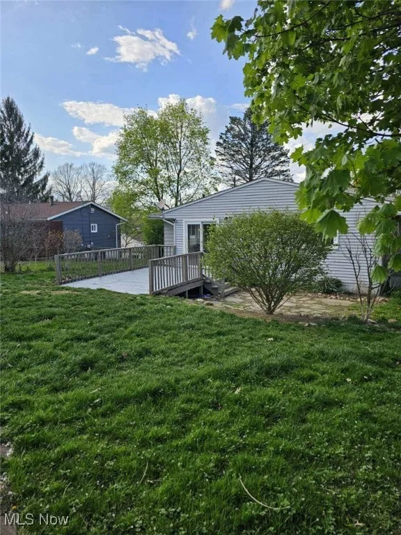 View of yard with a deck and fence