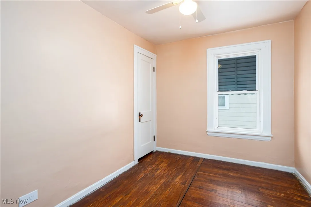Spare room with baseboards, ceiling fan, and dark wood finished floors