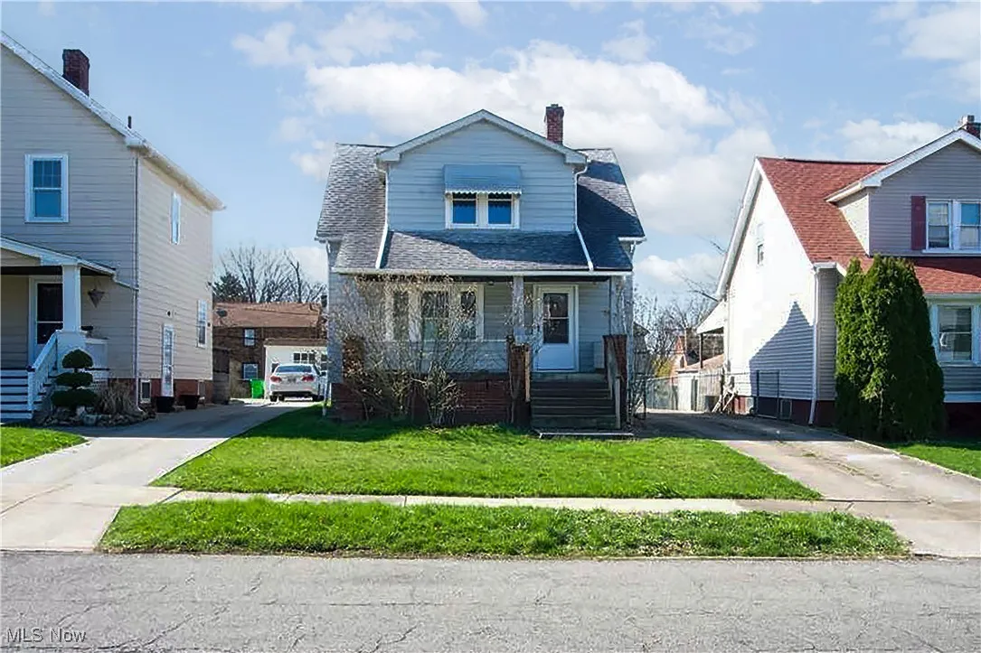 View of front facade with covered porch, concrete driveway, a chimney, and a front lawn