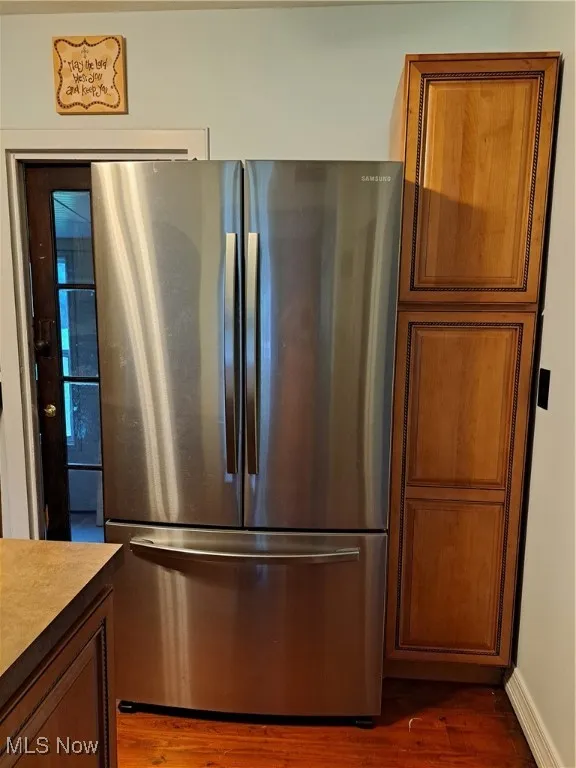 Kitchen featuring dark hardwood / wood-style flooring and stainless steel refrigerator