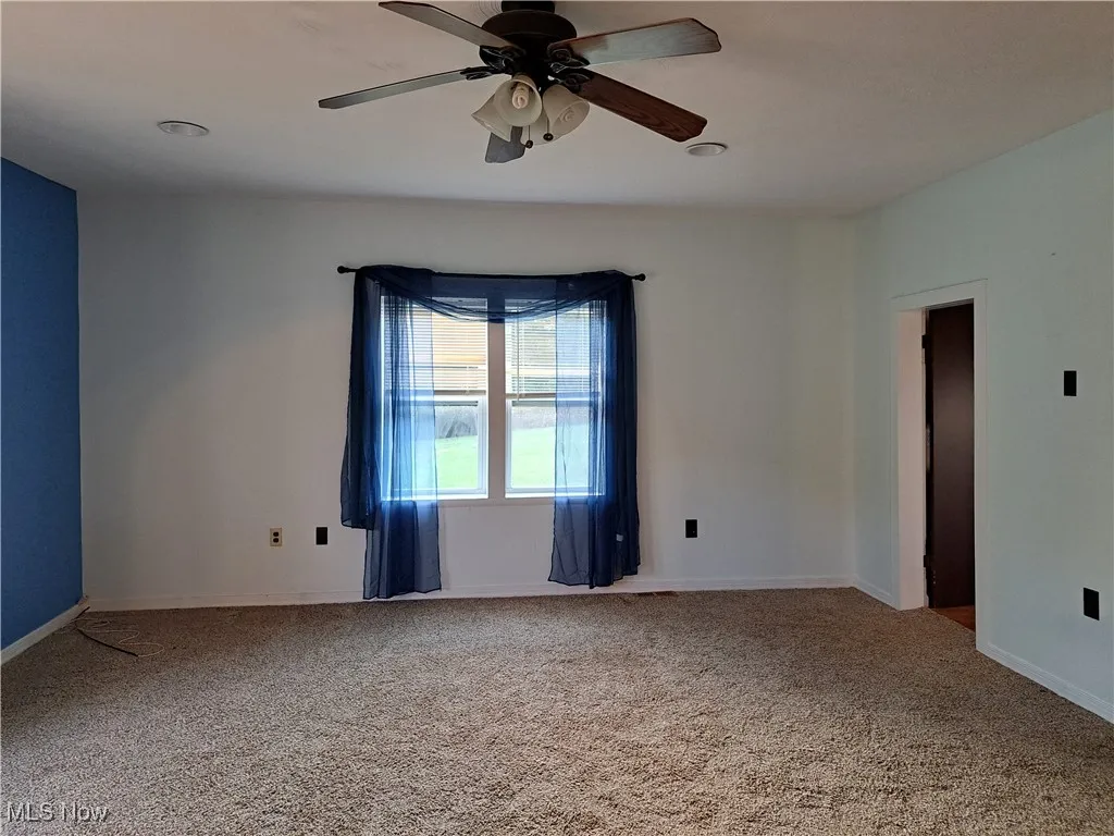 Carpeted family room featuring ceiling fan