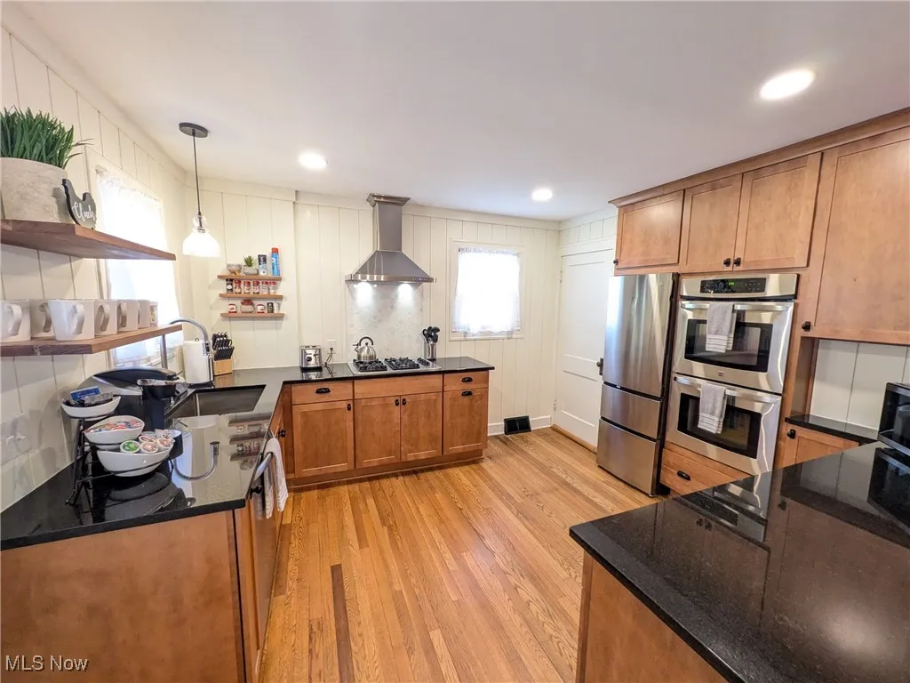 New chefs Kitchen with granite counters, recessed lighting, vented gas cooktop, double oven, all stainless appliances, breakfast bar & hardwood flooring!