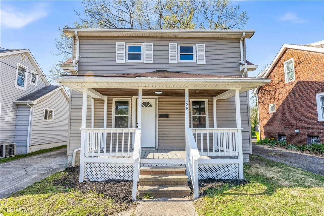 American foursquare style home with central air condition unit and covered porch