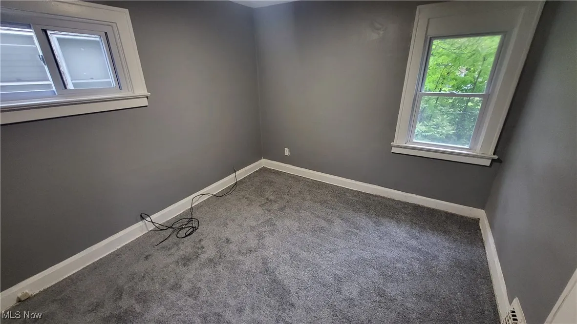 Carpeted empty room featuring baseboards
