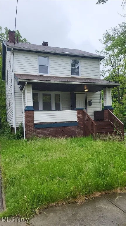 View of front of property with a chimney and a porch