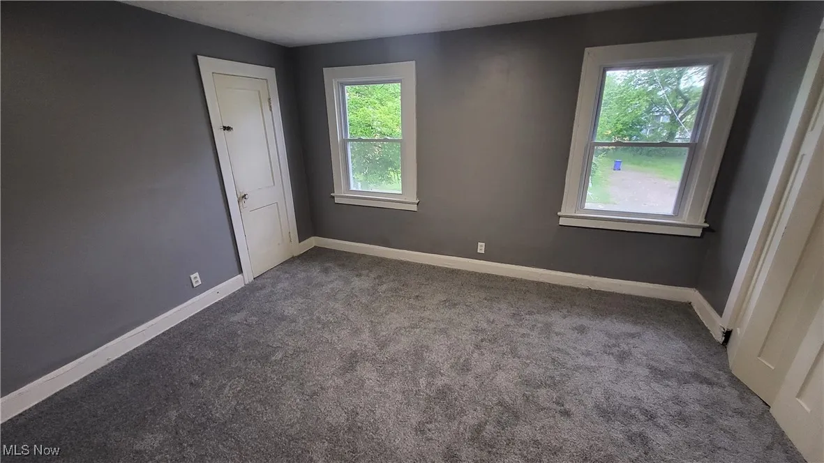 Carpeted spare room with baseboards
