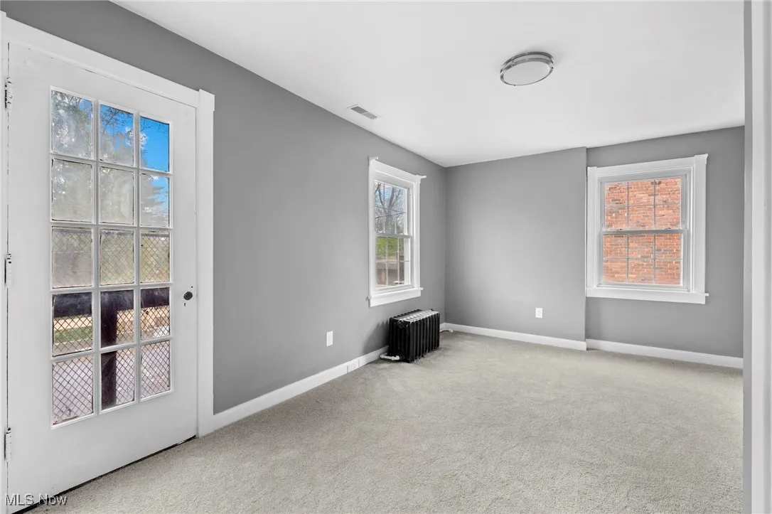 Carpeted spare room with radiator