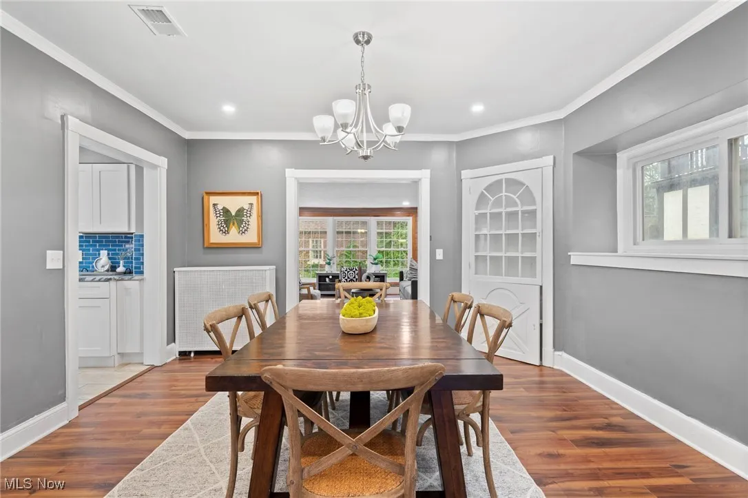 Dining space featuring ornamental molding, a chandelier, and wood-type flooring