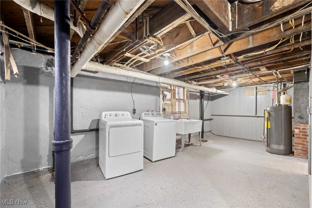 Basement with water heater, sink, and washing machine and dryer