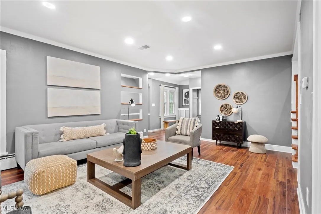 Living room featuring ornamental molding and hardwood / wood-style flooring