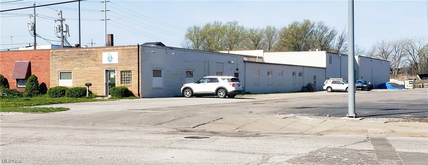 View of building exterior featuring uncovered parking